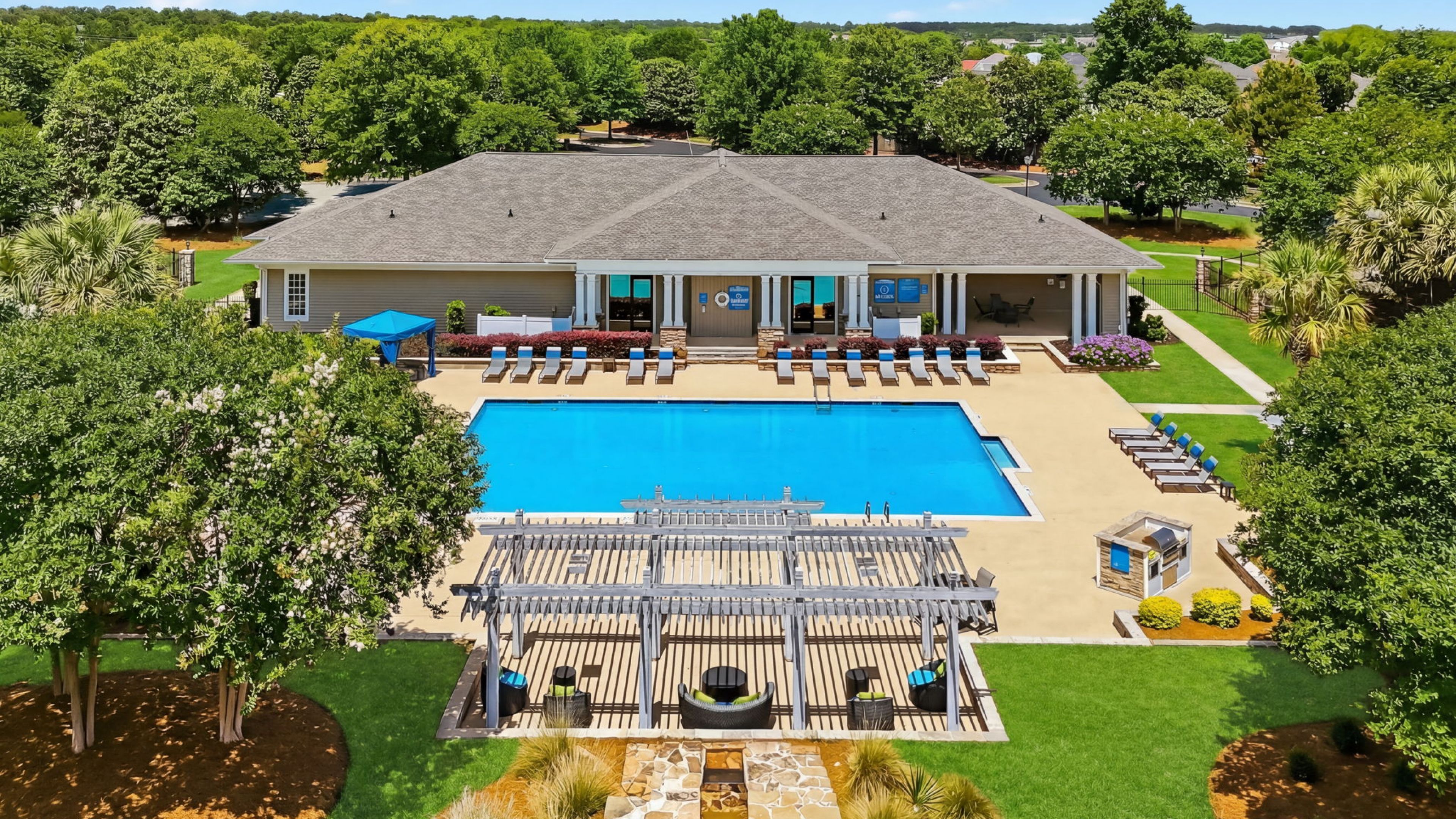 Outdoor patio with furniture and umbrella in the peaceful Hawthorne Meadowview complex in Warner Robins, GA