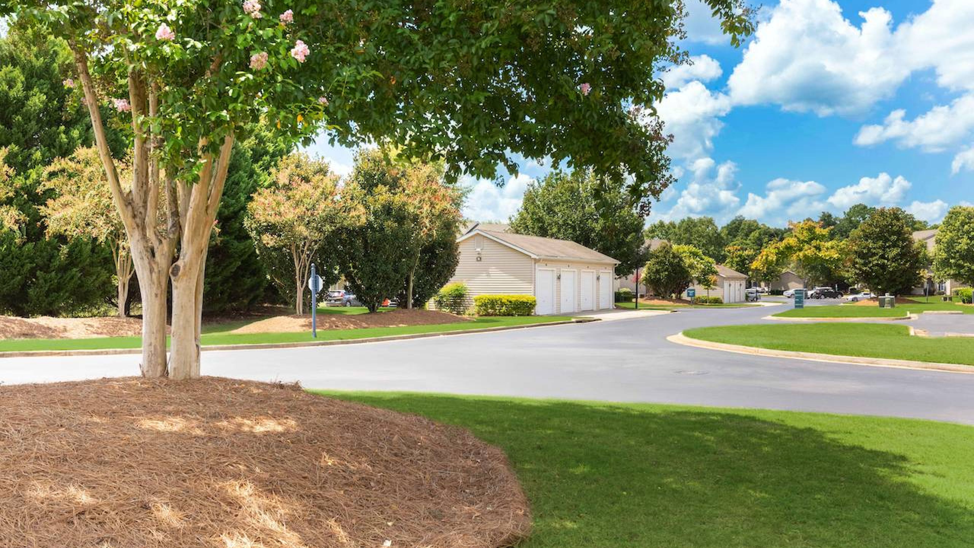 Outdoor patio with furniture and umbrella in the peaceful Hawthorne Meadowview complex in Warner Robins, GA